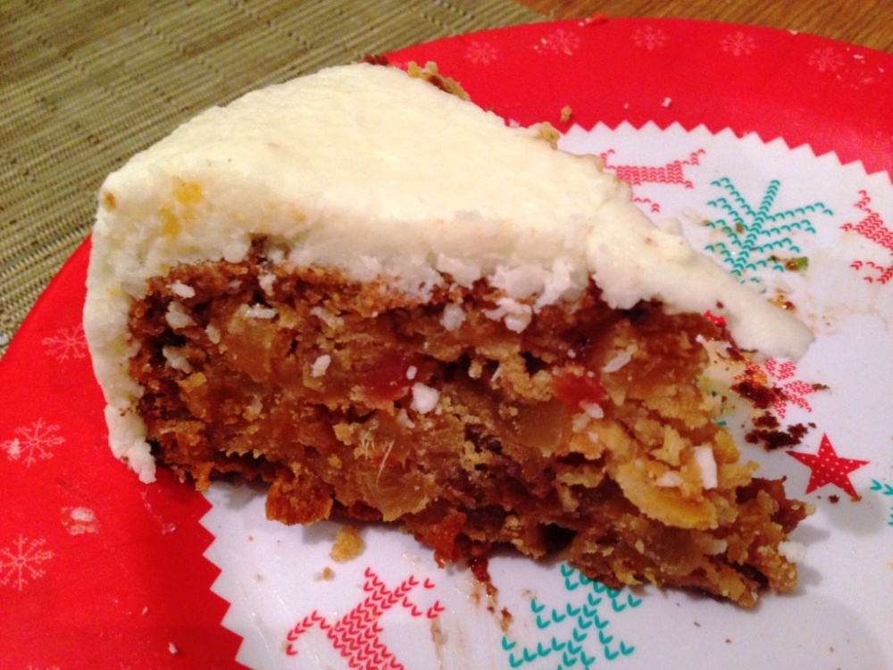 slice of tropical christmas fruit cake with coconut icing recipe and how to contains mango pineapple papaya apricot sultanas flavoured with rum and ginger