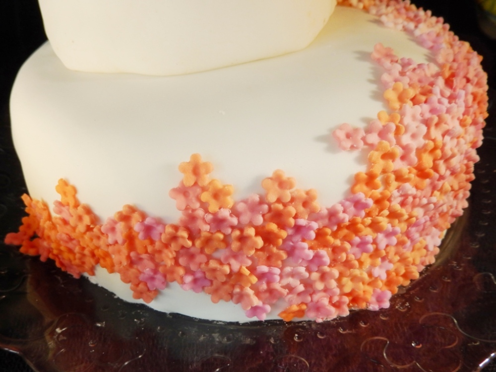 pink and orange cascade ombre flowers wedding cake on white icing